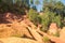 Ochre Trail in Roussillon, Sentier des Ocres, hiking path in a natural colorful area of red and yellow cliffs surrounded by green