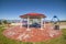 Octagon shaped picnic pavilion with view of colorful playground and scenic lake