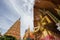 Octagonal pagoda and large golden Buddha statue at Wat Tham SuaTiger Cave Temple,Tha Muang District,Kanchanaburi,Thailand.