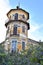 Octagonal tower with four floors, tiled friezes on facades, balconies and wrought iron railings.