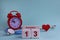 October 13. Day of the 13th month, calendar date. White wooden calendar blocks with date, clock and stethoscope on blue pastel