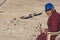 October 17th 2017 : A Tibetan Buddhist monk sitting and holding a wheel prayer with desert background in Ladakh
