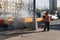 October 2017, Moscow, Russia. A worker in an orange vest like paper and dirt from the roadside pillars