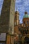 October 2021 Bologna, Italy: Saint Petronius statue across the Two towers, dome and blue sky. Travel destinations