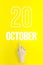 October 20th. Day 20 of month, Calendar date.Hand finger pointing at a calendar date on yellow background.Autumn month, day of the