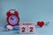 October 22. Day of the 22th month, calendar date. White wooden calendar blocks with date, clock and stethoscope on blue pastel