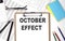 OCTOBER EFFECT text on paper sheet with chart,keyboard and calculator
