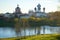 October evening on the Tikhvinka River. View of the temples of the Tikhvin Monastery, Russia