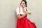 October fest concept.Beautiful german woman in typical oktoberfest dress dirndl holding a glass beer mug