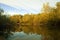 October forest reflected in the calm waters of a lake makes a mirror effect