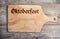 Octoberfest sign on cutting board, copy space, wooden background