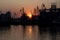 Odesa sea port gantry crane silhouettes at sundown sky background