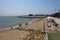 Odessa, Ukraine -2022: Metal military barriers, anti-tank hedgehogs on sea city beach. Vacationers sunbathe next to iron anti-tank