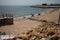 Odessa, Ukraine -2022: Metal military barriers, anti-tank hedgehogs on sea city beach. Vacationers sunbathe next to iron anti-tank