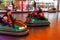 Odessa, Ukraine - June 13, 2016: A group of happy parents, boys and girls having fun and joy ride in bumper car on fairground