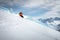 Off-piste skier on a glacier going down a beautiful alpine landscape. Blue cloudy sky in the background and high