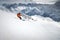 Off-piste skier on a glacier going down a beautiful alpine landscape. Blue cloudy sky in the background and high