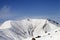 Off-piste slope with stones and snowy mountains