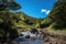 off-road adventure trail, with waterfall in the background and blue skies