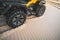 Off-road ATV wheel close up. Tourist on the Quad bike rides through the sandy desert. Extreme fun in the desert of MUI ne. Vietnam