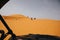 Off road buggies crossing dunes in the desert.