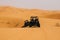 Off road buggies crossing dunes in the desert.