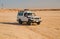 Off road car drive on desert landscape. Jeep for safari on sunny blue sky. Truck automobile travel in sand dune