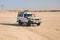 Off road car drive on desert landscape. Jeep for safari on sunny blue sky. Truck automobile travel in sand dune. Wanderlust and ad