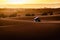 Off-road car with rooftop tent camping amids the sand dunes with sunrise. Desert of Erg Chebbi