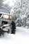 Off-road car in snowdrift on forest winter road. Wheel of four-wheel drive car in snow close-up