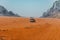 Off-road jeep going through incredible lunar landscape in Wadi Rum v