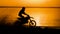 Off-road motorbike extreme cornering. Motorcyclist at sunset near the river. Extreme motocross bike, dirt from under the