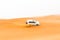 Off-road SUV vehicle speeding through sand dunes in the Arabian desert