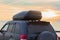 Off-road Vehicle with an Autobox on the roof by the Sea at Sunset