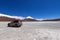 An off-road vehicle in front of the Laguna Verde and the snow-covered Licancabur volcano, Bolivia. Desert landscape of the Andean