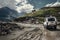 Off-road vehicle goes on the mountain way during the rainy season