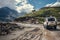 Off-road vehicle goes on the mountain way during the rainy season