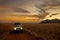 Off-road vehicle with roof tent on a sandy track in the sunset in the Naukluft Mountains in Namibia