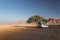 Off-road vehicle with roof tent on a sandy track in the sunset in the Naukluft Mountains in Namibia