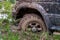 Off-road vehicle stuck in the mud. Dirty offroad car in swamp. Adventure travel concept. 4x4 SUV got bogged. Journey, tourism