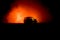 Off roader jeep silhouette on dark toned foggy sky background. Car with light at night.