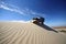 off-roader scaling daunting sand dune under clear blue sky