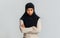 Offended black muslim woman in hijab standing with folded arms over gray background