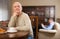 Offended elderly man sitting at table with disgruntled adult son