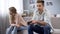 Offended girl turned away from boyfriend who indifferently playing video games