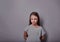 Offended, punished kid girl with serious emotions looking on dark wall background
