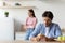 Offended sad young caucasian wife ignoring husband in minimalist kitchen interior