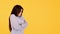 Offended young girl asian unhappy on a yellow background. Copy space
