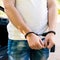 an offender standing in handcuffs near the car. Concept of arrest the driver, violation of rules and drinking alcohol while