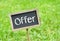 Offer - chalkboard with text on green grass background